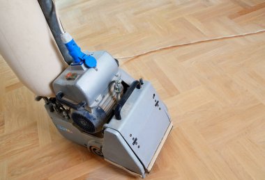 Zemini zımparalama makinesiyle zımparalıyorum. Apartmanda tamirat var. Marangoz parke ahşap parke döşeme bakım işi yapıyor.                               