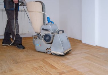 Zemini zımparalama makinesiyle zımparalıyorum. Apartmanda tamirat var. Marangoz parke ahşap parke döşeme bakım işi yapıyor.                               