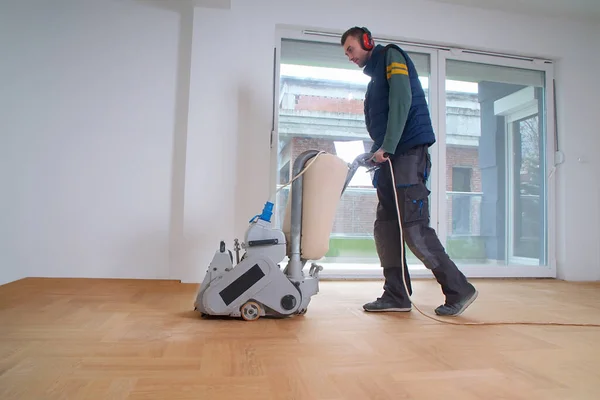 Zemini zımparalama makinesiyle zımparalıyorum. Apartmanda tamirat var. Marangoz parke ahşap parke döşeme bakım işi yapıyor.                               