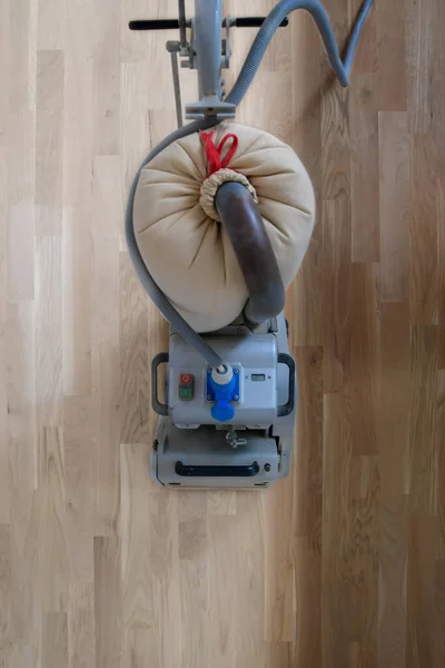 Scraping hardwood floor with the grinding machine. Repair in the apartment. Carpenter doing parquet wood floor polishing maintenance work by grinding machine — Stock Image Scraping Hardwood Floor Grinding Machine Repair Apartment Carpenter Doing Parquet Stock Image