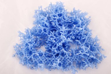 Beyaz arkaplanda el yapımı dantel örgü boncuklar.