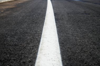 Beyaz yansıtma çizgisi olan asfalt yol dokusu. Yeni bir yol, yeni bir yüzey yeni bir asfalt yol