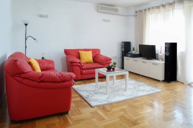 Modern bir oturma odasının iç çekimleri. Geniş bir daire. Kırmızı deri koltuklu oturma odası.