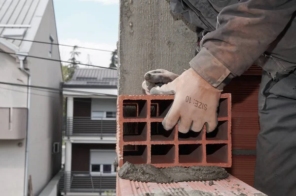 Worker builds a brick wall in the house