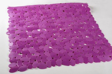 Arka planda desenli banyo için mor kauçuk paspas. Mor plastik paspas, vakum bardakları ve deliklerle bebek banyosu için kayma önleyici.
