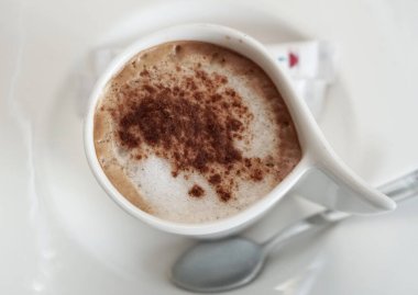 Bardaki masanın üstünde bir fincan cappuccino.