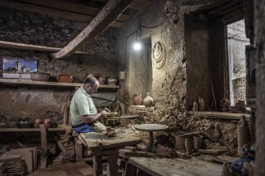 Erkek çömlekçi çömlek çarkında demlik yapıyor. Terracotta çömlekçi çocuk. Arazi merkezi olan çömlekçilik hakkında fikir üreten adamlar.