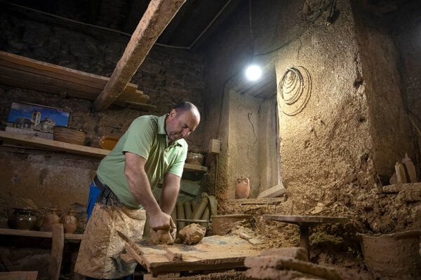 Скульптор создает скульптуру из глины в мастерской. Процесс изготовления фигурки из глины. Аккуратная формовочная глина