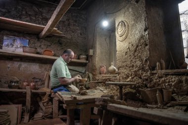 Erkek çömlekçi çömlek çarkında demlik yapıyor. Terracotta çömlekçi çocuk. Arazi merkezi olan çömlekçilik hakkında fikir üreten adamlar.