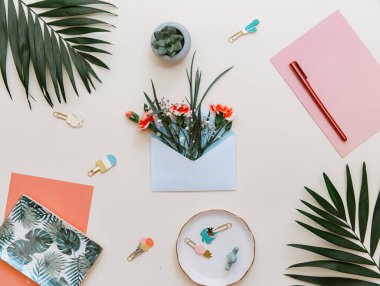 Düz yatıyordu yaz kompozisyon. Yaratıcı kavramı tropikal yaprak ve davetiyeler. Çiçekli mavi bir zarf içerisinde. Üstten görünüm, kopya alanı