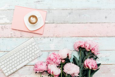 Kahve fincanı ve eski püskü masaya pembe peony çiçek. düz yatıyordu tarzı üstten görünüm