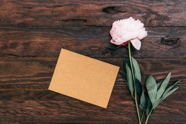 Koyu ahşap masa üzerinde boş kart ile güzel şakayık
