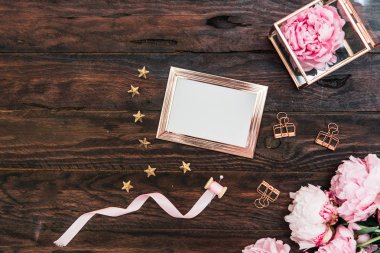 Koyu ahşap masa üzerinde beyaz boş kart ile güzel peonies