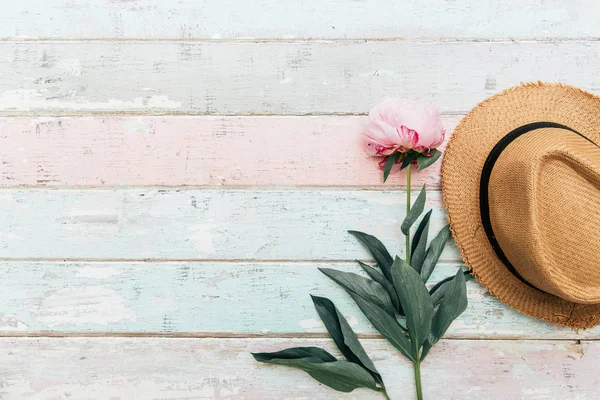 Ahşap plakalar arka plan mavi güzel Şakayık Çiçeği ve ışık üzerinde hasır şapka