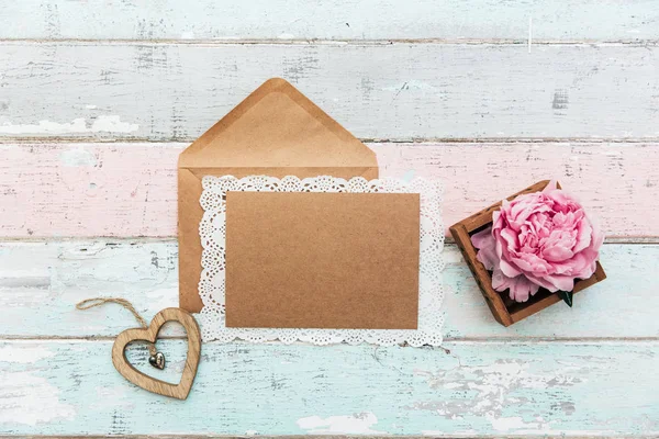 Zarf ile düz yatıyordu boş oyun kağıdı davet. Tatlı pembe şakayık çiçeği ile şenlikli arka plan. Metin için yer ile üstten görünüm