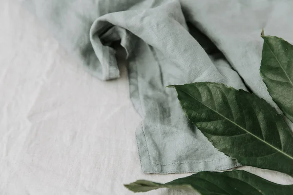Близкий Вид Льняной Салфетки Зелеными Листьями Белом Фоне — стоковое фото