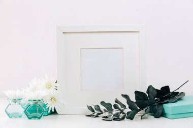 beyaz çiçek vazolar ve beyaz zemin üzerine yeşil yaprakları ile şube kadar boş çerçevenin görünümünü kapat