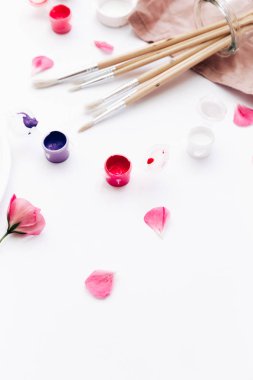 pembe çiçek, boya fırçaları ve boyalar bakış beyaz masa üzerinde kapatın