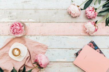 ahşap masa üzerinde peonies, dizüstü bilgisayarlar ve kahve üstten görünüm