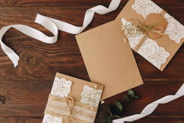 Düz araçları DIY ahşap bir masa üzerinde yatıyordu: kağıt, makas, iplik, zeytin dalı. Kendi kendine yapılan zarf harfler için. Üstten görünüm.