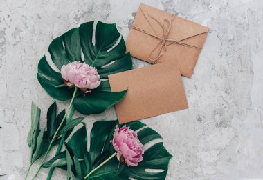 Zarf ve tepsi arka plan üzerinde pembe solgun Şakayık zanaat. Üstten Görünüm, düz lay, anneler günü, kadın gün kavramı. 