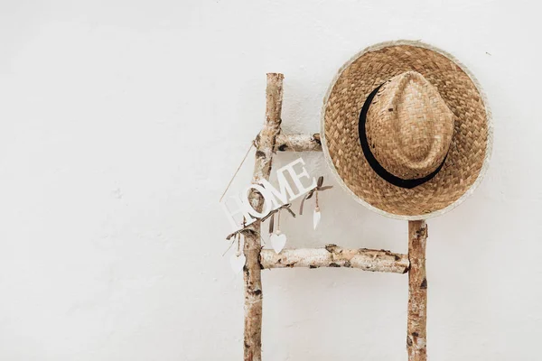 Straw hat with wooden staircase and Home letters minimal lifestyle home decor. Home sweet home