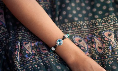 Bir kadının elinde el yapımı bilezik.