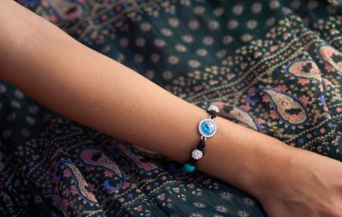 Bir kadının elinde el yapımı bilezik.