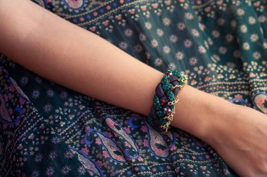 Bir kadının elinde el yapımı bilezik.