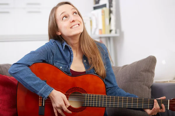 女性は自宅でギターを弾く — ストック写真