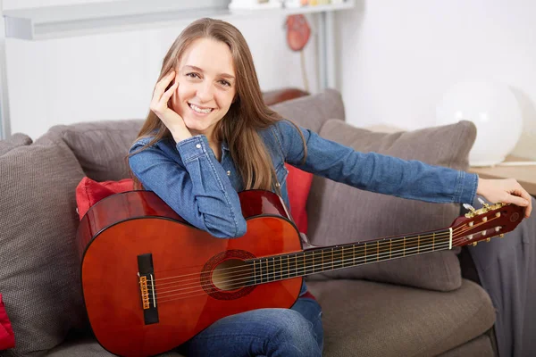 女性は自宅でギターを弾く — ストック写真