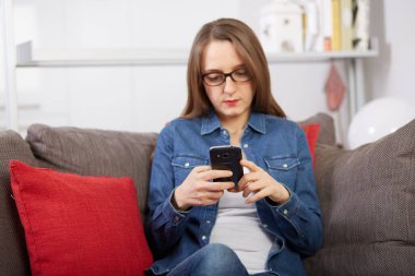 kadın kanepede mobil konuşuyor