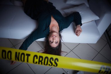 Suç mahalli. Kadın kanepede ölü yatıyor.