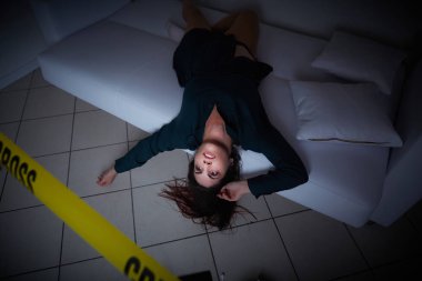 Suç mahalli. Kadın kanepede ölü yatıyor.