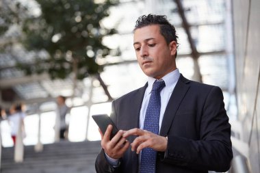 Kentsel çevrede cep telefonuyla konuşan iş adamı