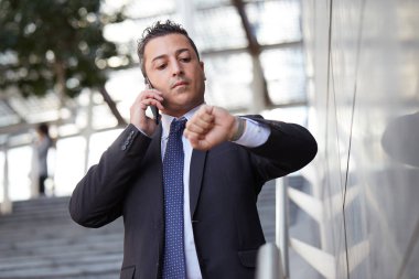 Kentsel çevrede cep telefonuyla konuşan iş adamı