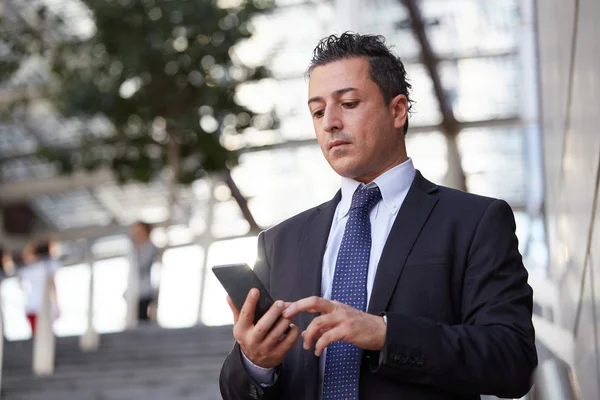 Kentsel çevrede cep telefonuyla konuşan iş adamı