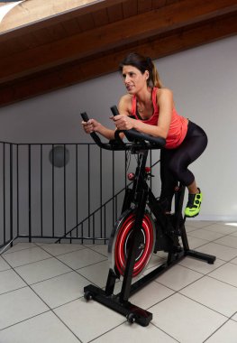 Evde dönen bir kadın. Bacakları ve kardiyo eğitimi için egzersiz yapıyor.