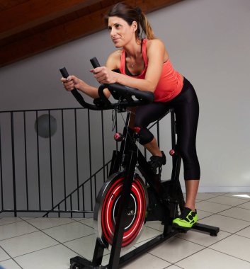 Evde dönen bir kadın. Bacakları ve kardiyo eğitimi için egzersiz yapıyor.