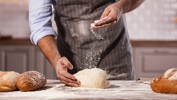 hands of the baker 's male knead tough
