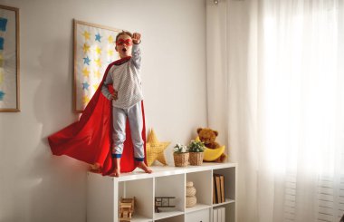 hom, maske ve kırmızı pelerini ile bir süper kahraman kılık kız çocuk