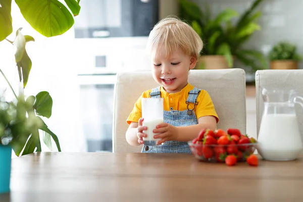 Glücklicher Kleiner Junge Isst Erdbeeren Mit Milch Bei Hom — Stockfoto