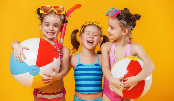 滑稽有趣的快乐的孩子在游泳衣和游泳眼镜跳上彩色背景 — 图库照片