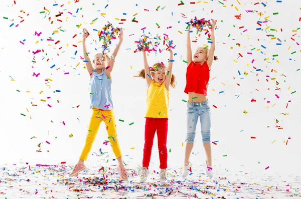 快乐的孩子在假日有乐趣和跳跃在多彩多姿的五彩纸屑在白色背景 — 图库照片