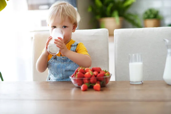 Glücklicher Kleiner Junge Isst Erdbeeren Mit Milch Bei Hom — Stockfoto