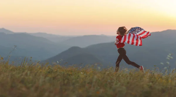 Natur で夕日を楽しむアメリカ合衆国の国旗を持つ若い幸せな女 — ストック写真