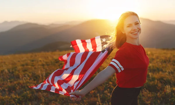 Natur で夕日を楽しむアメリカ合衆国の国旗を持つ若い幸せな女 — ストック写真