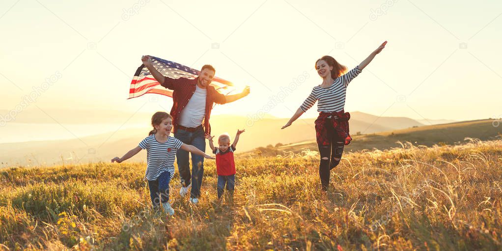 happy family with the flag of america USA at sunset outdoor