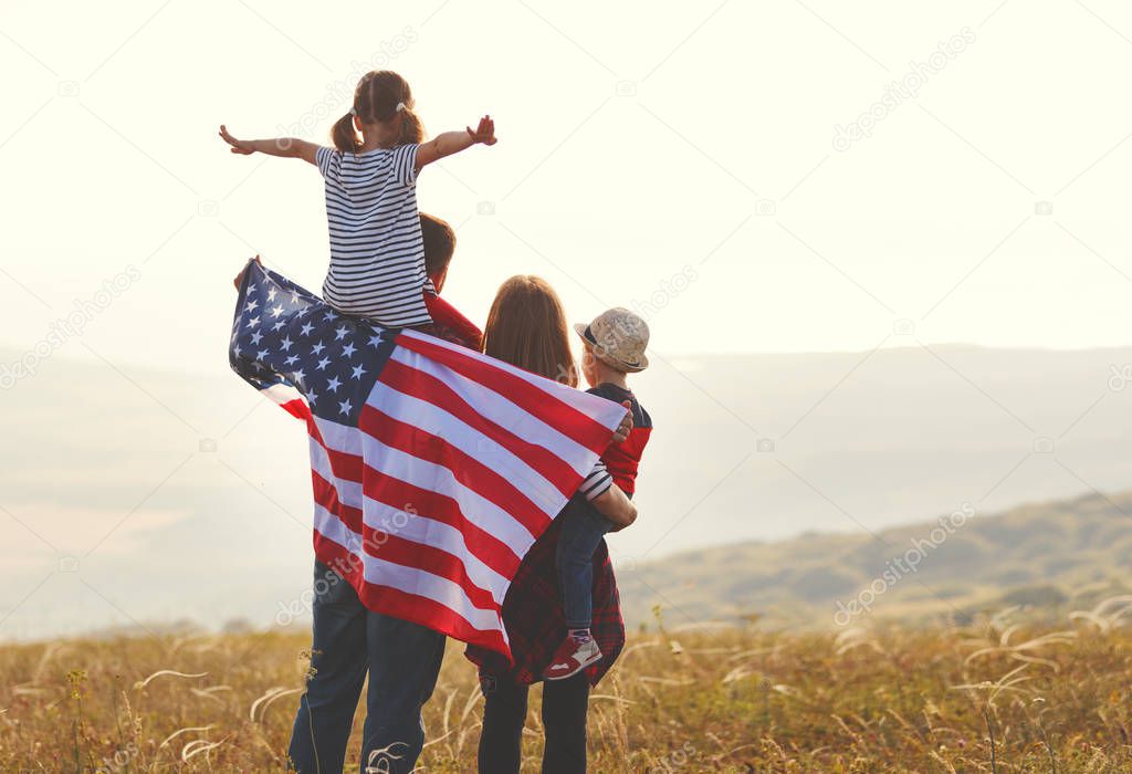 happy family with the flag of america USA at sunset outdoor