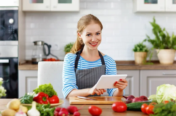 Mutlu Kadın Bir Tabloyla Reçete Üzerinde Mutfakta Sebze Hazırlama — Stok fotoğraf